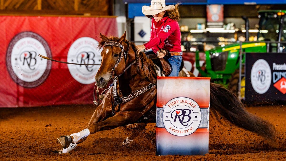 Brittany Tonozzi turns a barrel on a red horse in a red shirt