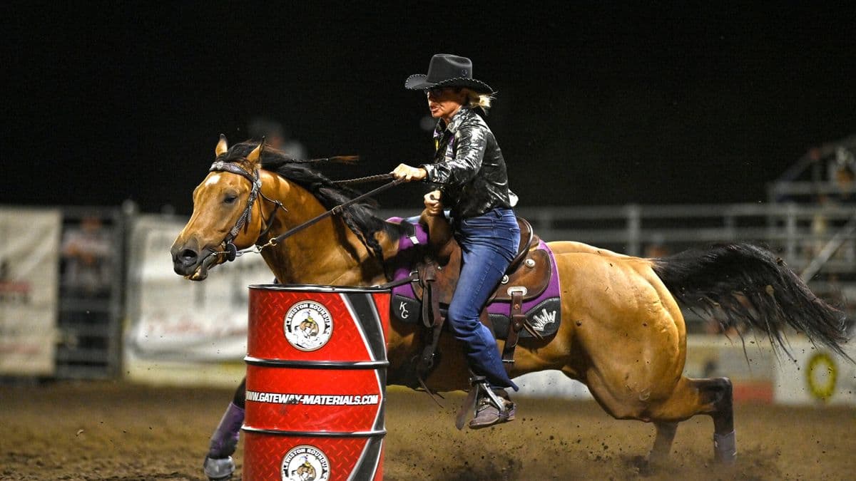 Kathy Grimes turns a barrel on her buckskin horse