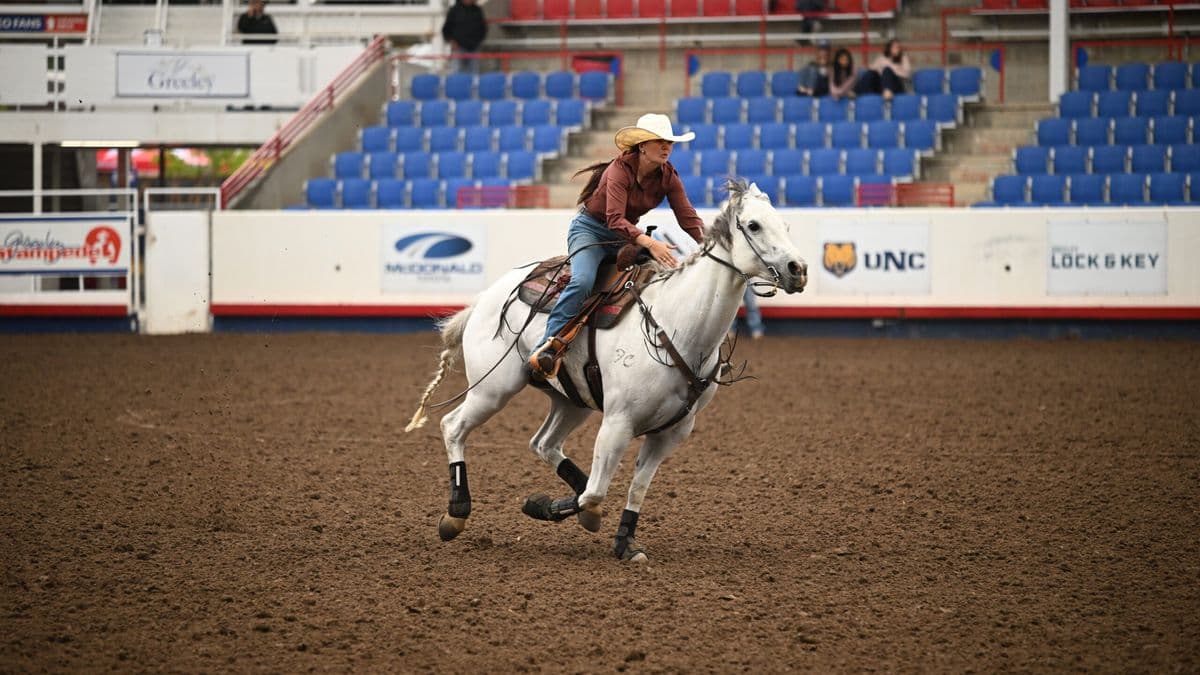 Emma Smith turns a barrel on a grey horse