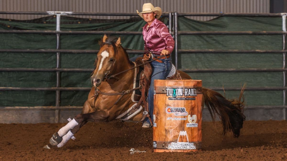 Taylor Langdon rounds a barrel on her stallion "Strutter"