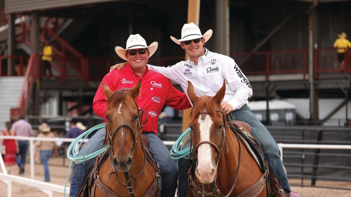 Korbin Rice and Cooper Freeman on horseback together, arms around each other's shoulders