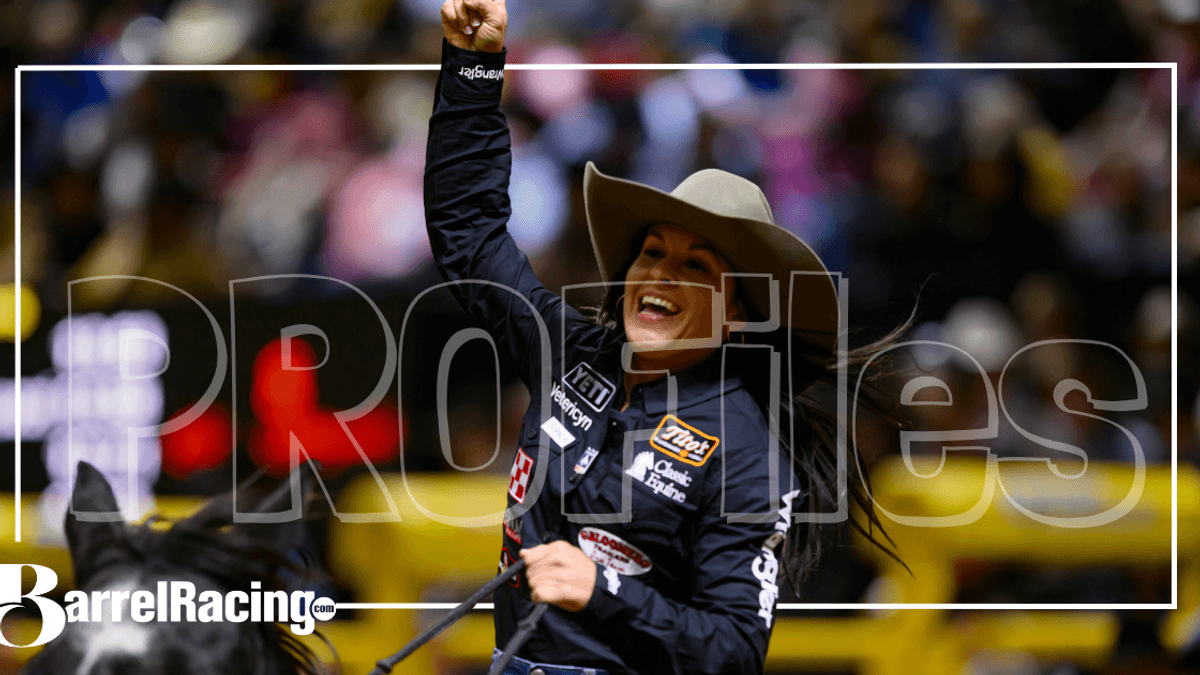 Barrel racer in a cowboy hat raises a fist in celebration while riding out of the arena, with BarrelRacing.com and "Profiles" overlays