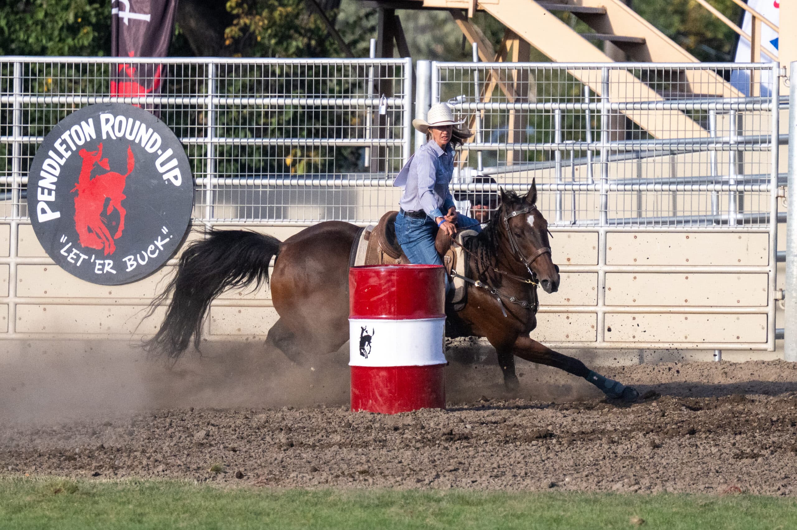 katelyn scott turns a barrel that's red and white at the Pendleton Round-up