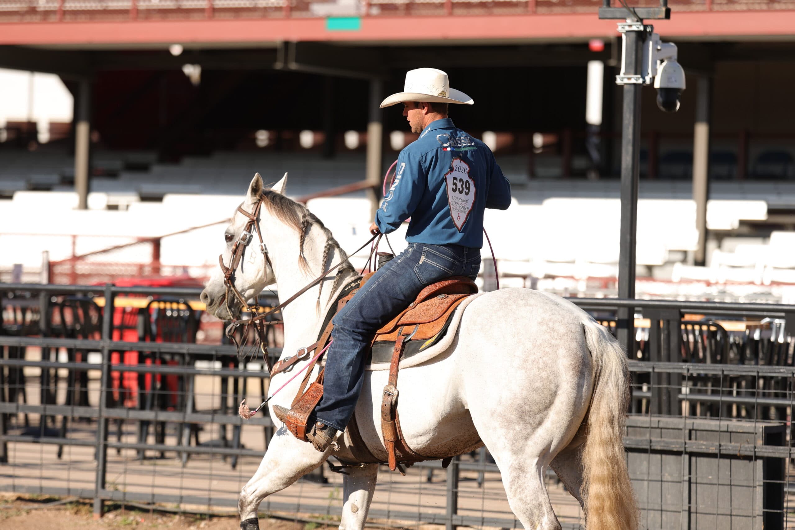 Competitor number 539 rides a gray horse in Western saddle at a rodeo arena during daylight competition