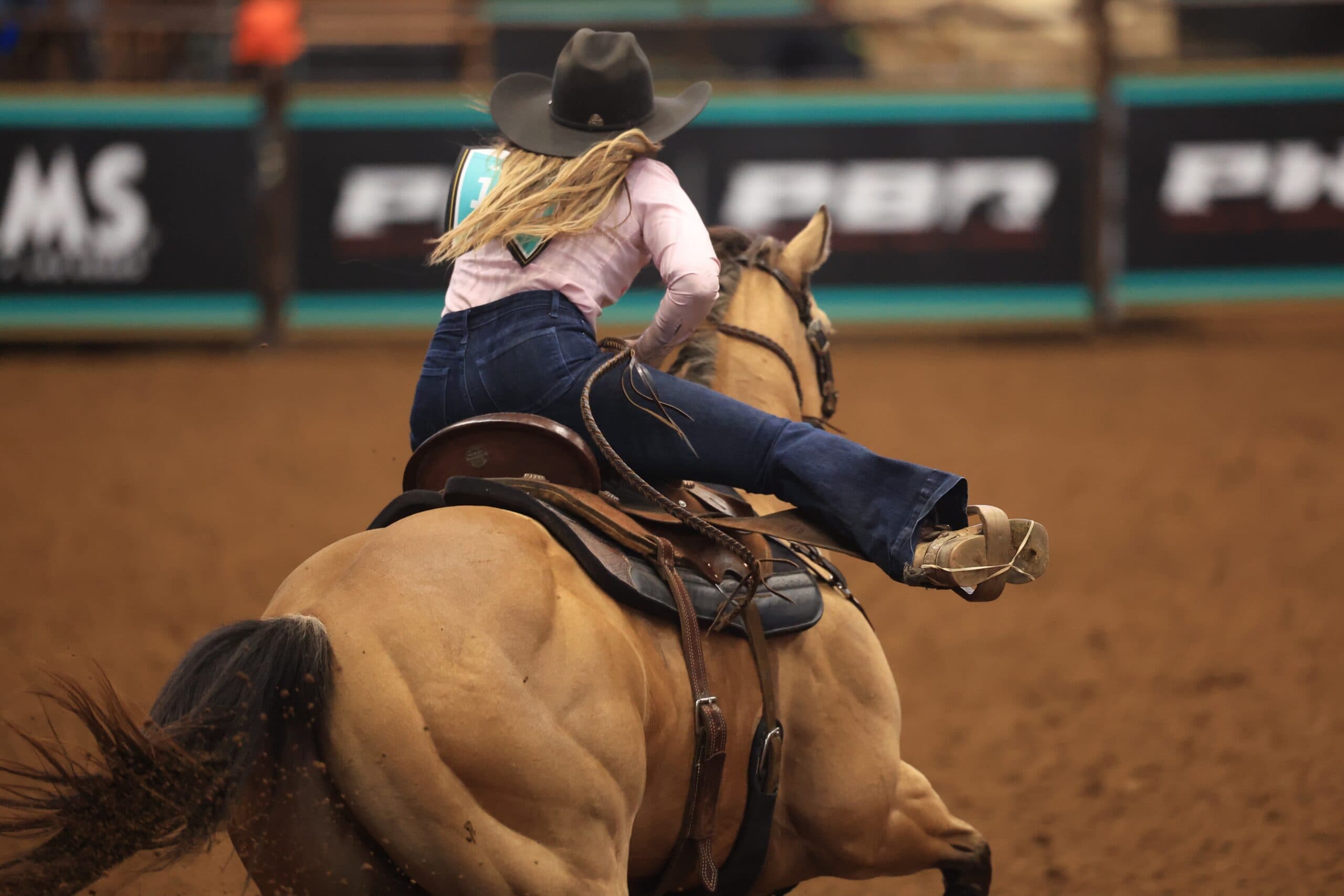 Kappie Bryant rides her horse around a barrel