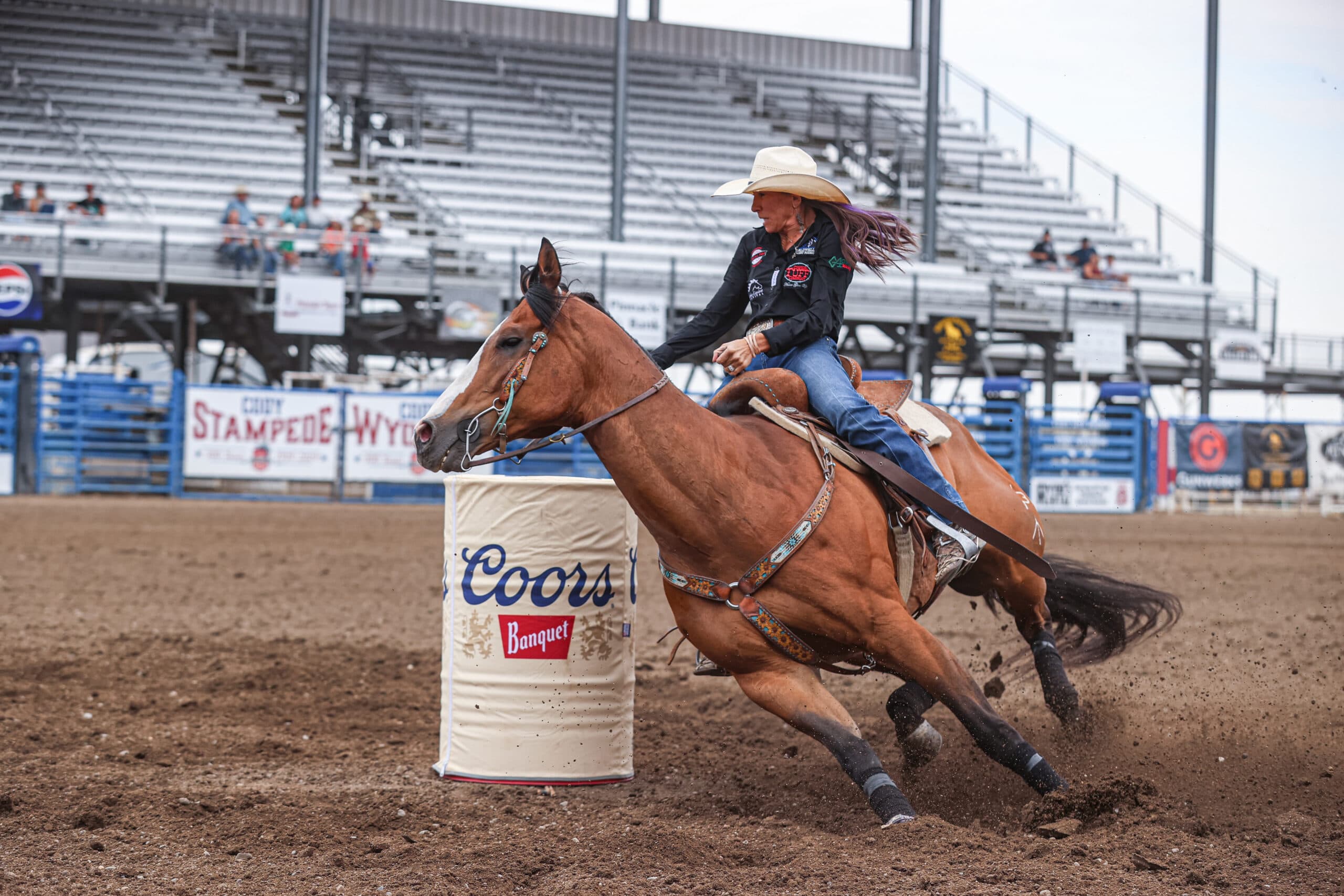 Megan Mcleod Sprague turns a barrel on a bay horse