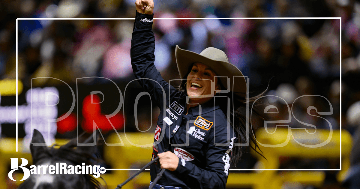 Barrel racer in a cowboy hat raises a fist in celebration while riding out of the arena, with BarrelRacing.com and "Profiles" overlays