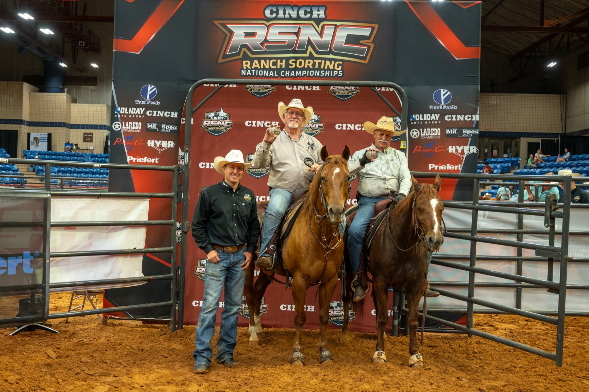 Russell Klostermann and Scott Stresen-Reuter on horseback holding championship buckles at the 2026 Cinch RSNC World Finals in Fort Worth