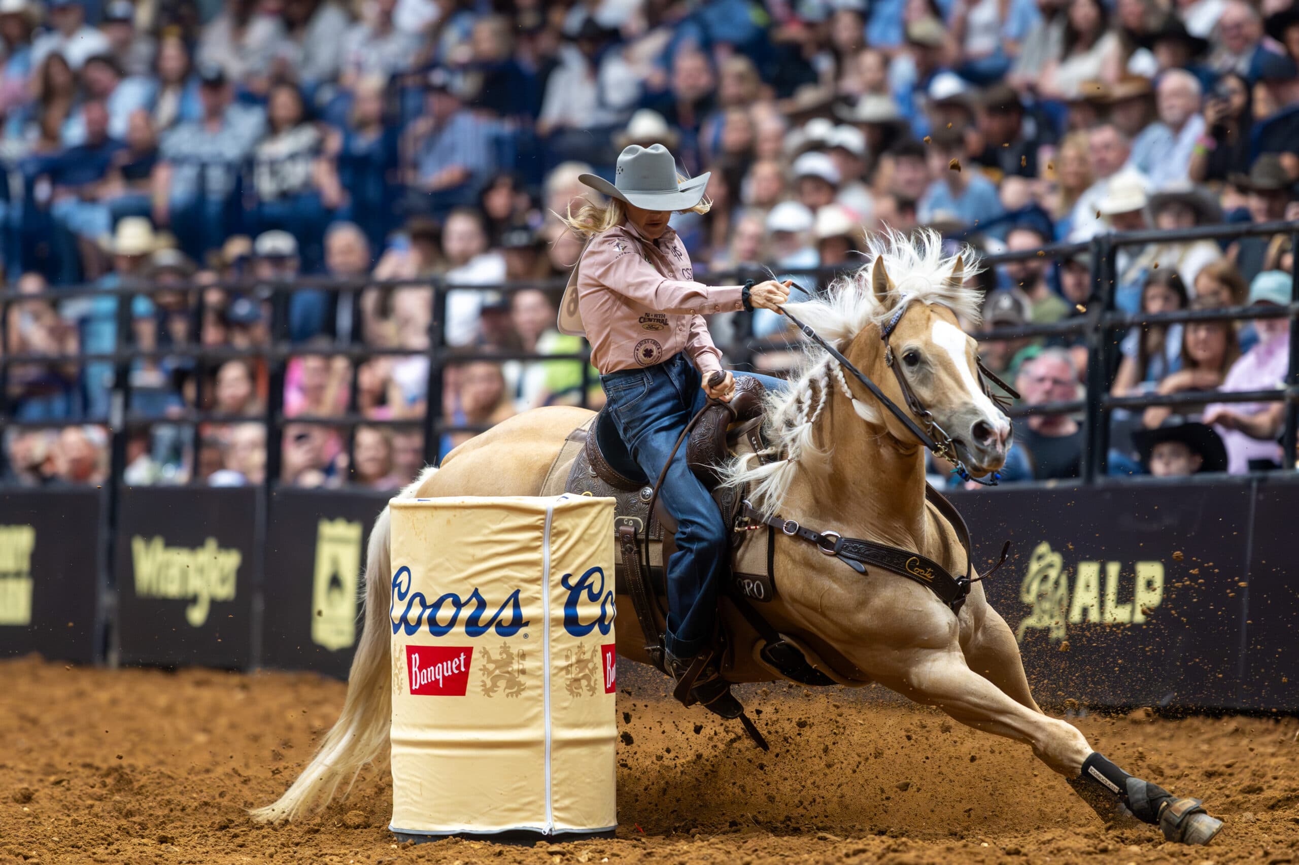 Carlee Otero turns a barrel on her yellow mare Regina