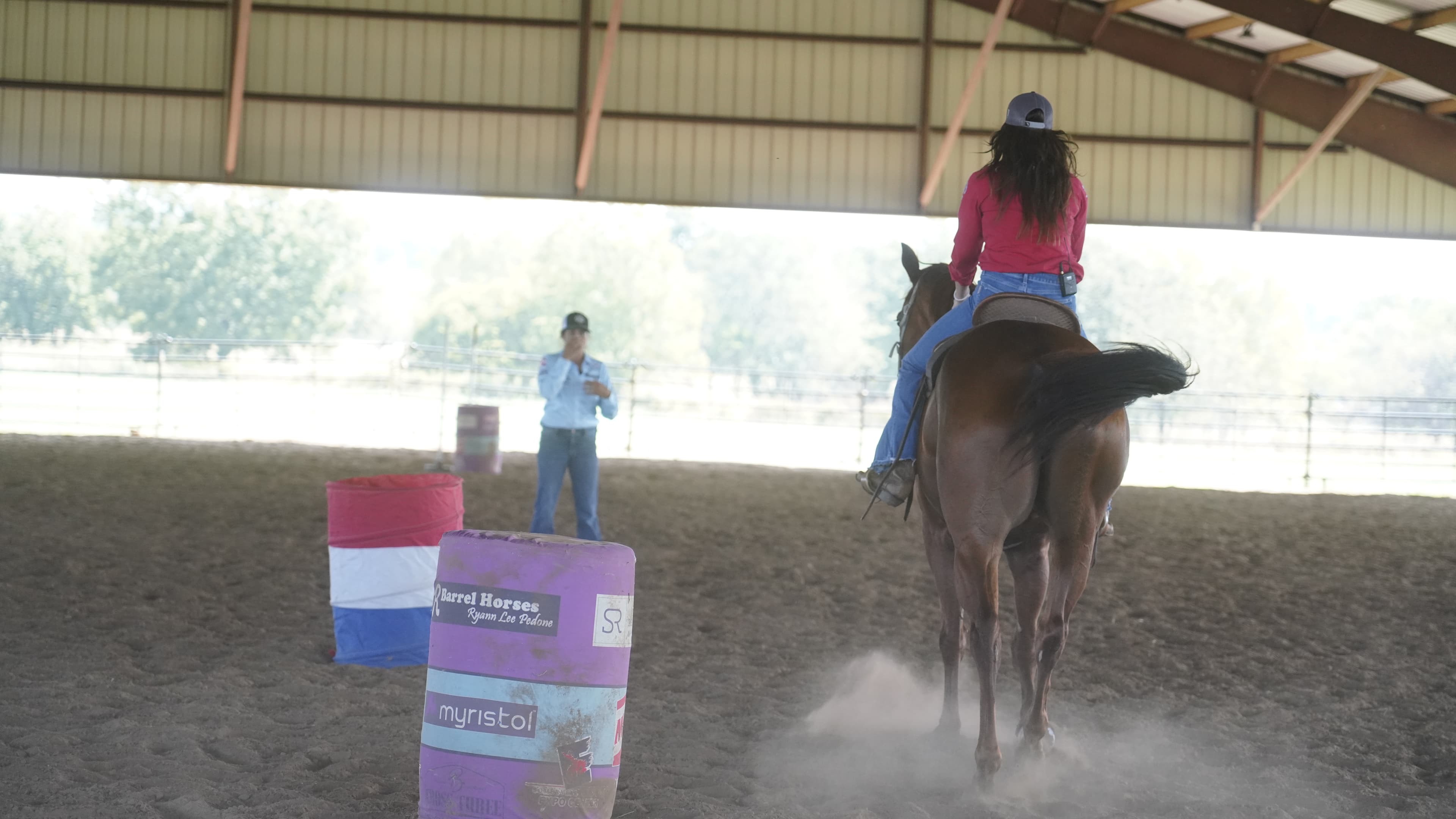 Beginner barrel racer learning with trainer