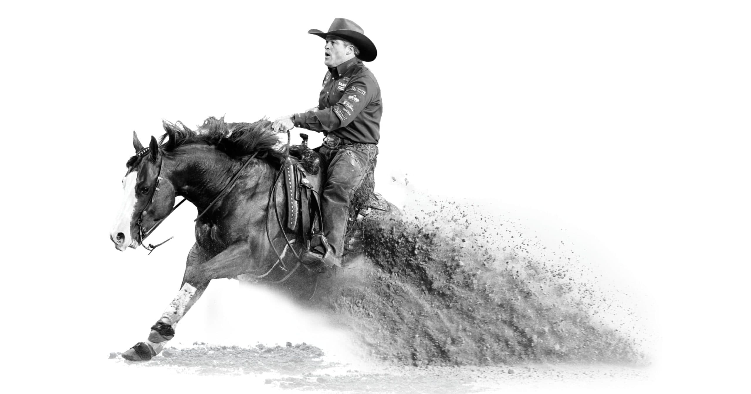 Cowboy in chaps and felt hat slides his horse to a hard sliding stop, throwing up a spray of dirt